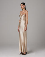 Model wearing a Liquid Silk Slipdress in a neutral color, side view
