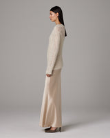 Model wearing Open Mesh Boatneck Sweater in ivory, paired with a satin skirt.