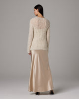 Model wearing Open Mesh Boatneck Sweater in ivory with a satin slip dress, back view