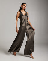 Model wearing a silk palazzo jumpsuit in forest taupe