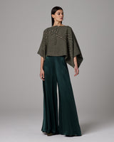 Model wearing green silk palazzo pants with a patterned top