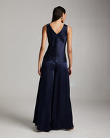 Model wearing a navy silk palazzo pants and tank top from the back