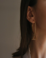 Model wearing Millapani Amuleto Hoops earrings, showcasing design and charm.