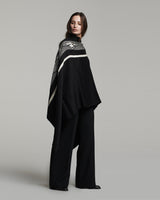 Model wearing a black and white Wide Diagonal Alpaca Wrap, showcasing its design.