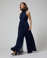 Model wearing a navy Crinkle Chiffon Palazzo Jumpsuit, walking elegantly