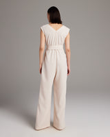 Back view of a model wearing a V Neck Jumpsuit in pearl color