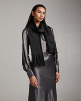 Model wearing the Lineas Fringe Scarf, styled with a grey dress, showcasing the scarf's fringe detail.