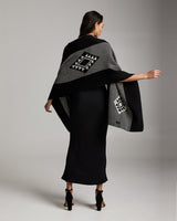 Model wearing a black and grey Estrella Shawl with geometric patterns, showcasing the back view.