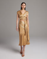 Model wearing a gold tie dye bias midi skirt with a wrap top