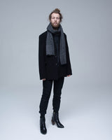 Model wearing a black and grey striped Chevron scarf, standing against a neutral background.