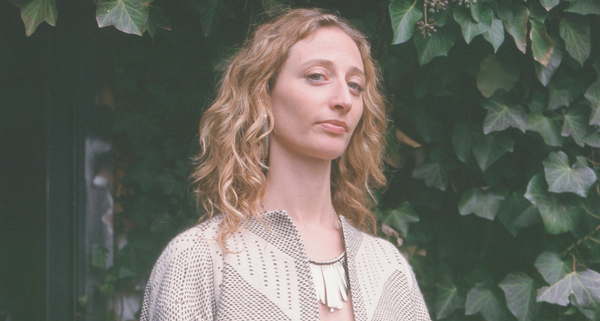 Kabira Stokes standing in front of ivy, wearing a statement necklace