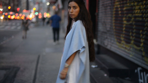 Bianca Valle walking on a city street, wearing a light blue garment