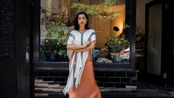 Aditi Mayer standing outside a shop, wearing a shawl and a long skirt.