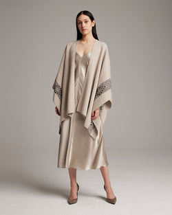 Model wearing a long Estrella duster in textured cotton over a satin dress