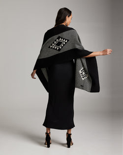 Model wearing a black and grey Estrella Shawl with geometric patterns, showcasing the back view.